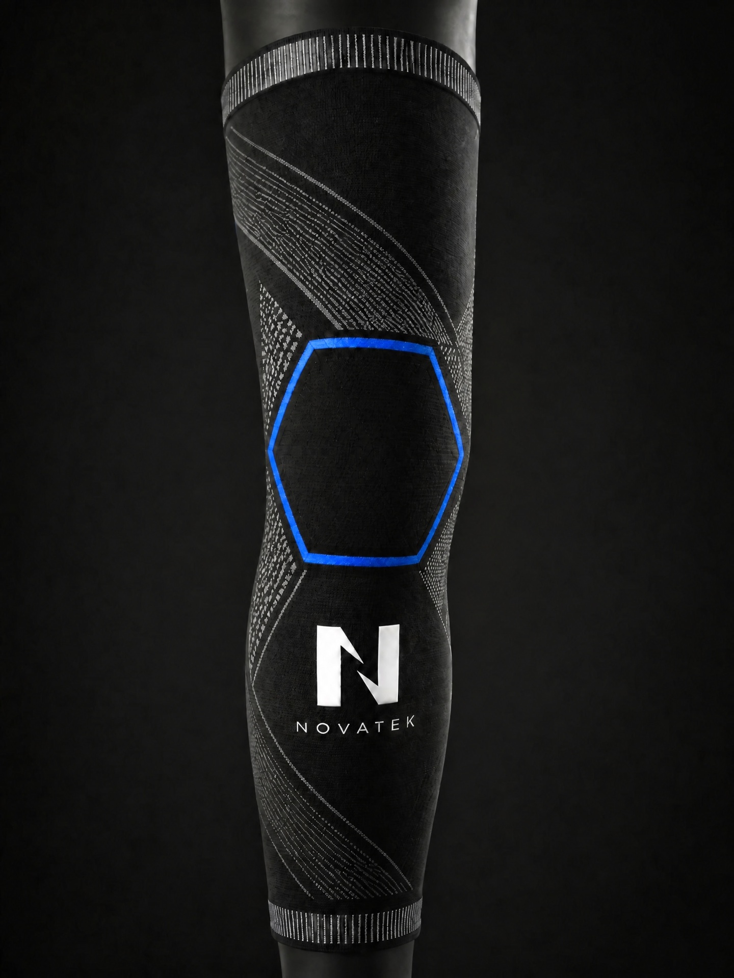 Manchon de compression full-leg NOVATEK noir, motif tricoté et hexagone bleu au niveau du genou, logo NOVATEK sur le mollet